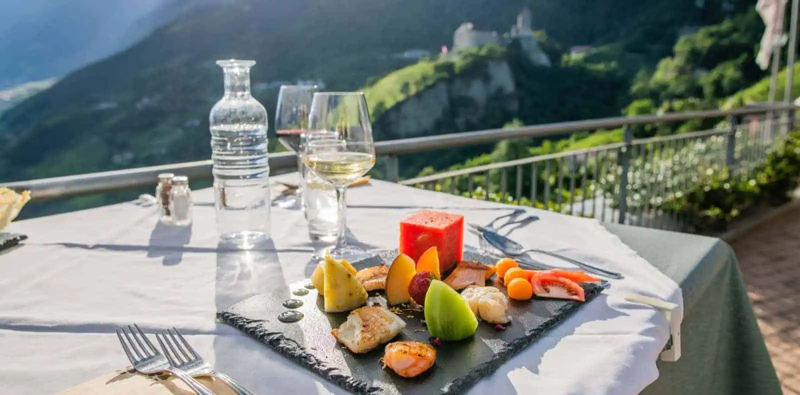Tisch auf der Terrasse, gedeckt mit frischem Obst. Hundehotel Mair am Ort.