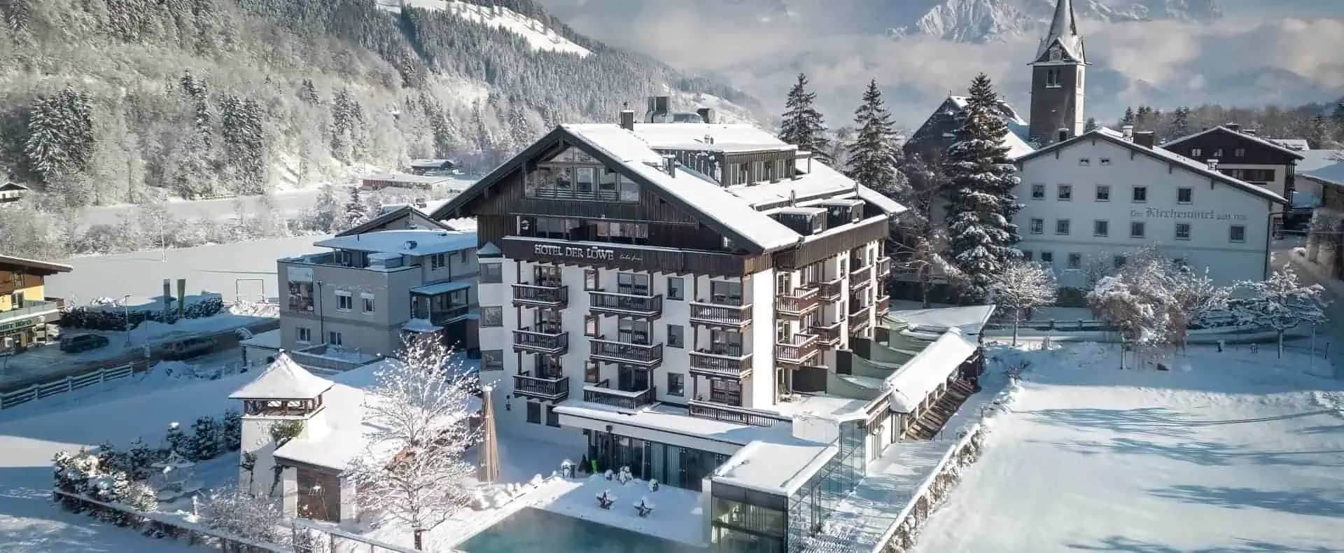 Lebe Frei der Löwe Aussenansicht Winter mit Pool. Verschneite Landschaft und die Berge im Hintergrund.
