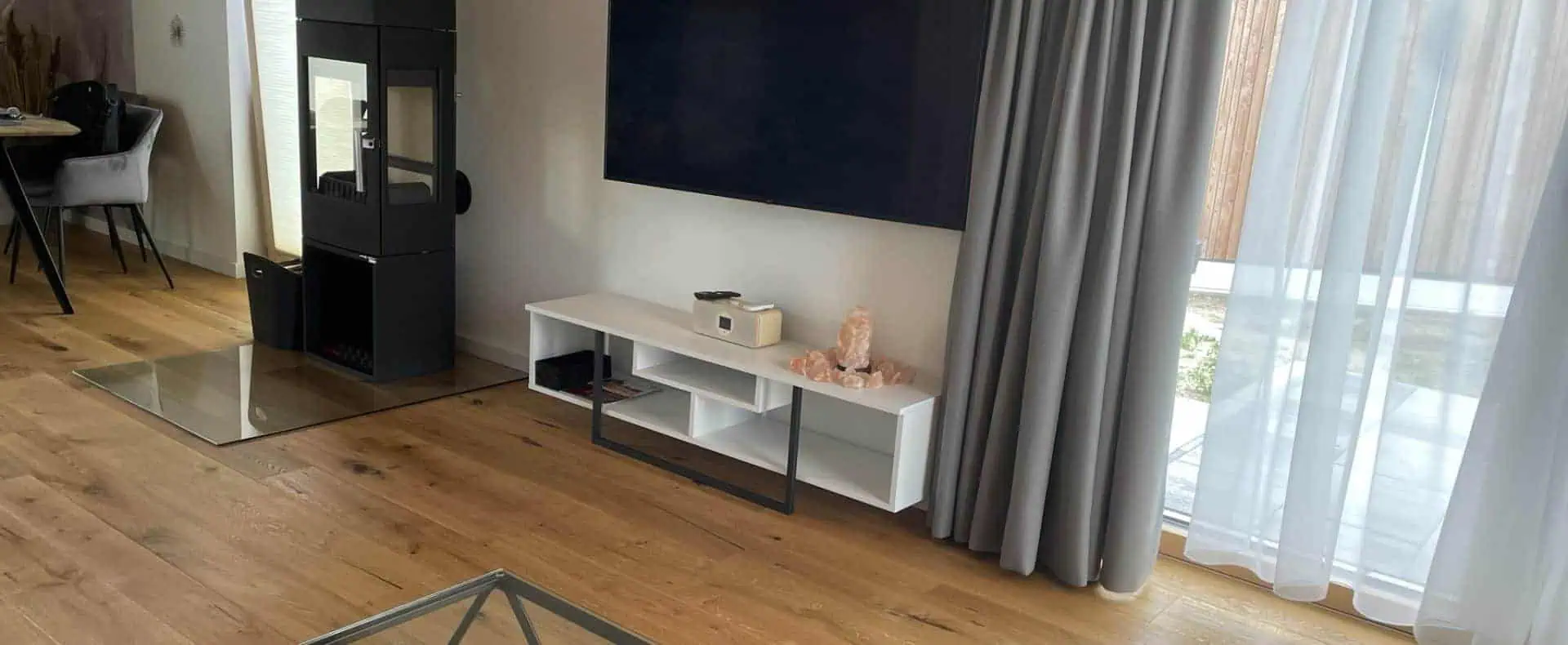 Wohnbereich mit Kamin neben dem Fernseher, Waidlerland Ferienpark