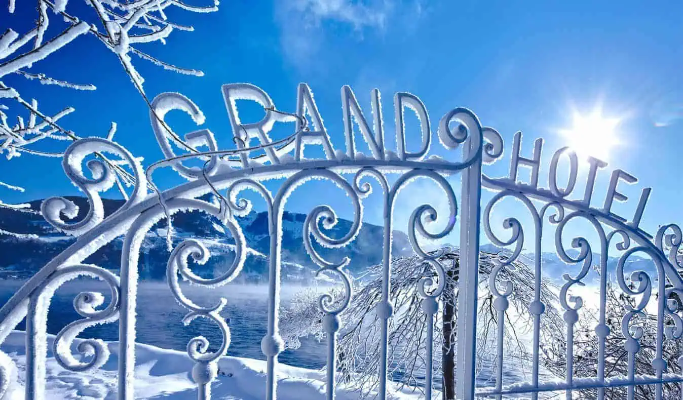 Tor mit der Aufschrift Grandhotel im Winter, mit Reif bedeckt, rundherum Schnee