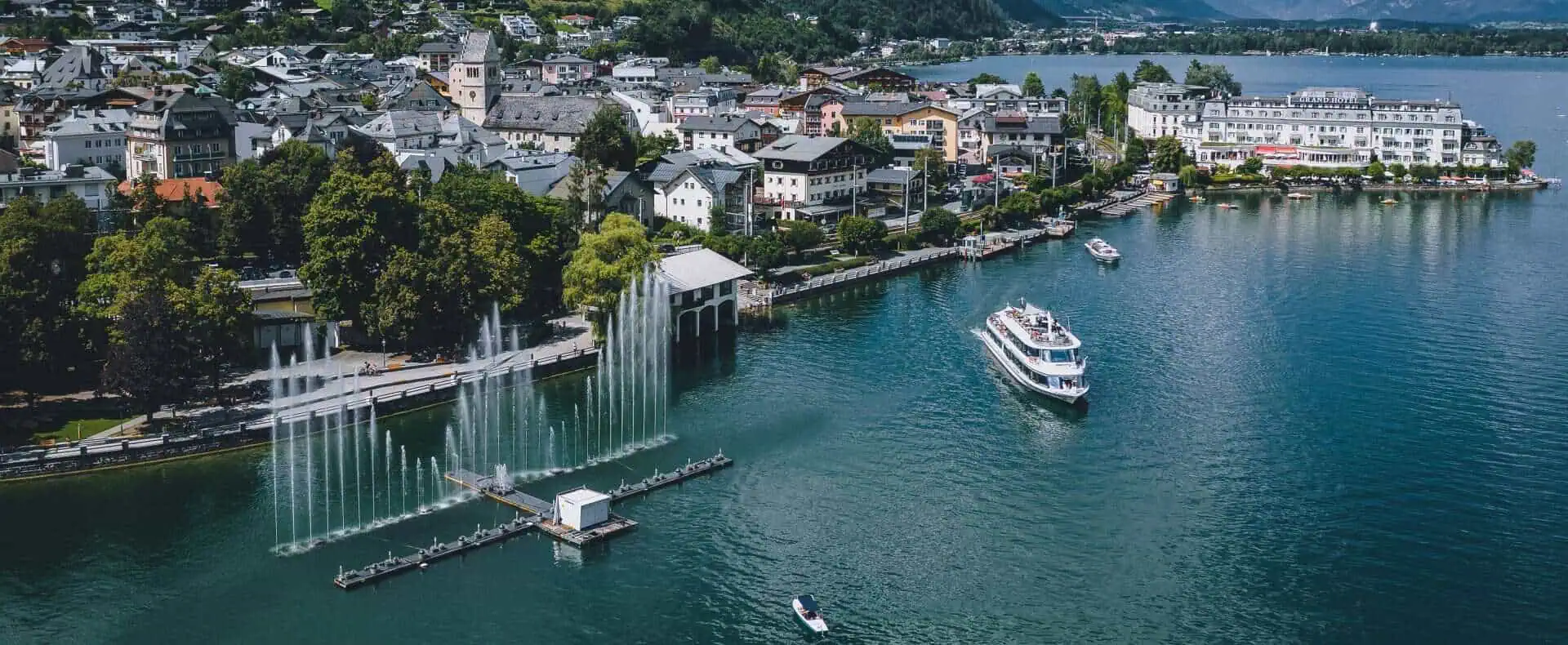 Luftaufnahme vom Granhotel Zell am See mit Schiffen und im Hintergrund Berge