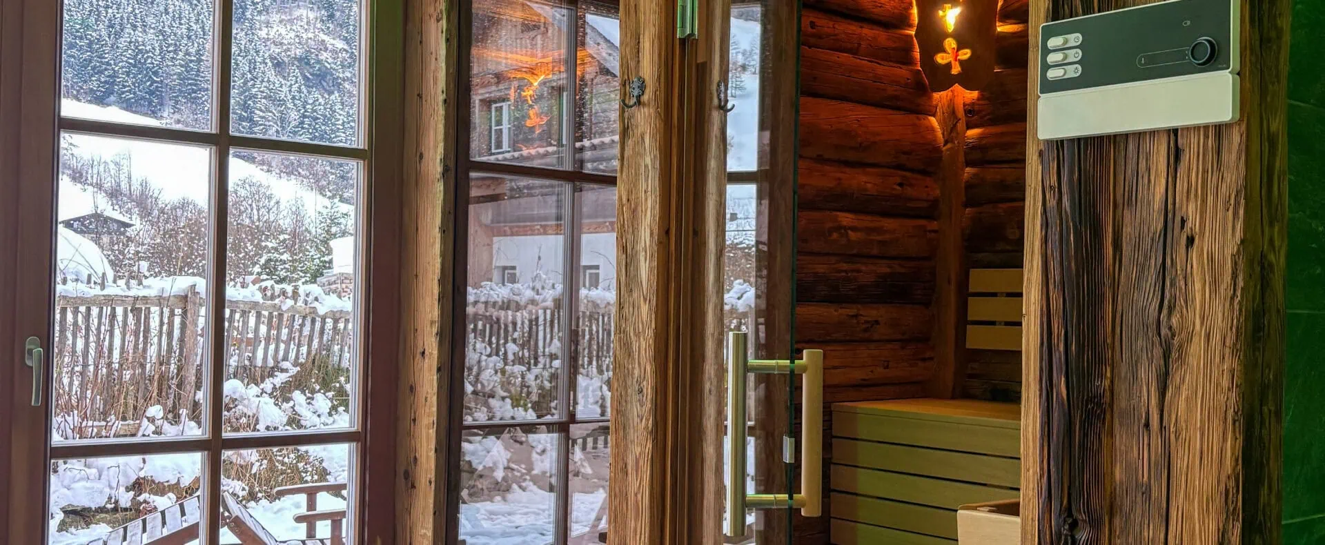 Gemütlicher Wellnessbereich mit Sauna, Holzinterieur und Blick auf die verschneite Terrasse der Birnbaum Chalets.