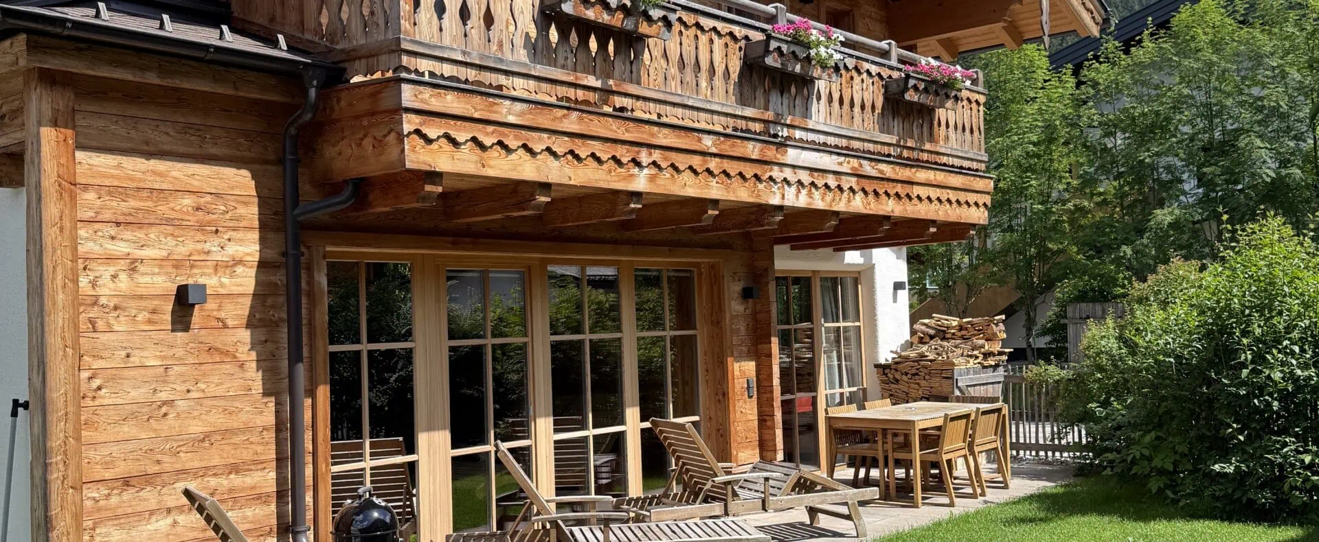 Birnbaum Chalets mit Garten, Terrasse und Hund vor dem alpinen Holzchalet