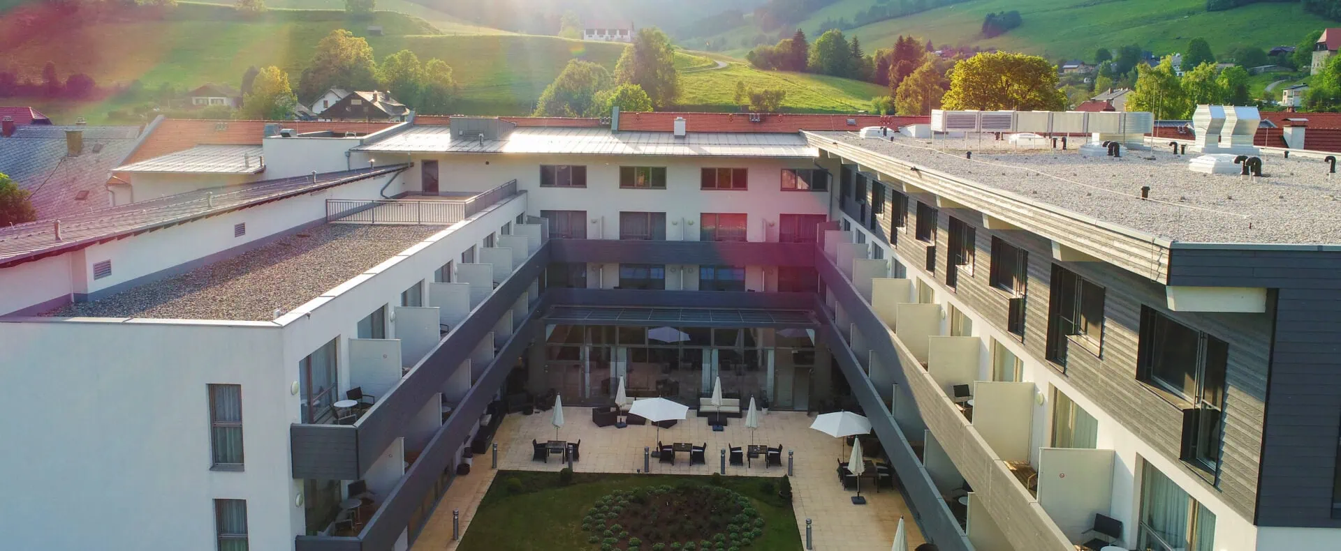 Drohnenaufnahme des Auszeit Hotels St. Lambrecht mit Innenhof und Naturblick