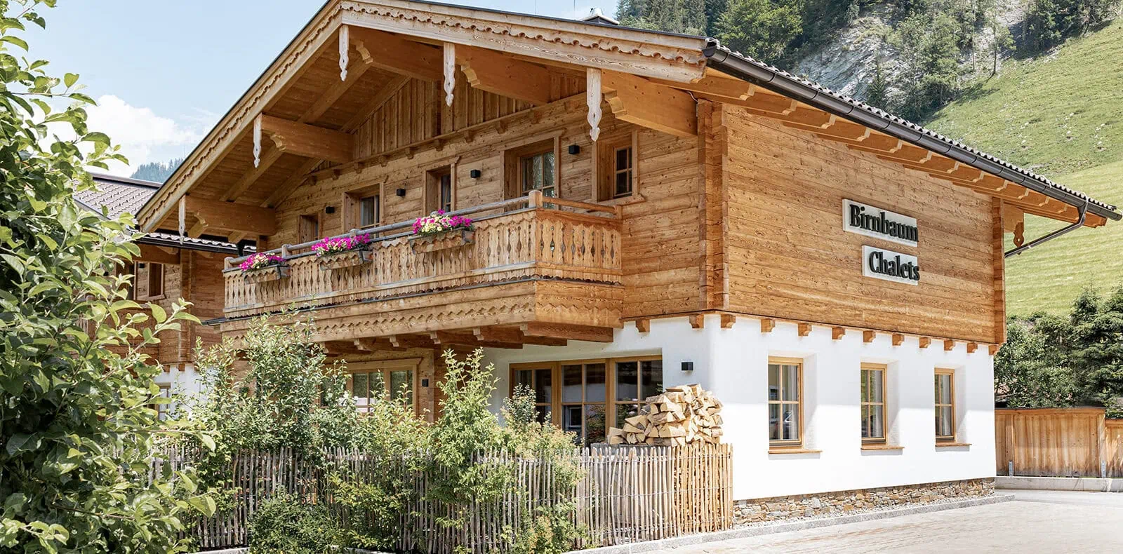 Außenansicht der Birnbaum Chalets mit Holzbalkon und Bergkulisse