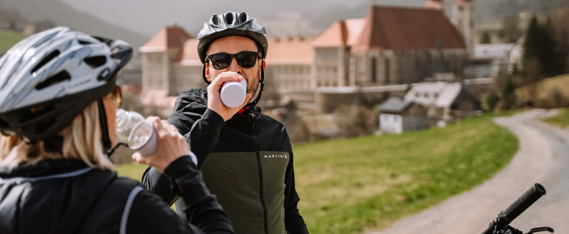 Radfahrer bei einer Pause mit Blick auf St. Lambrecht
