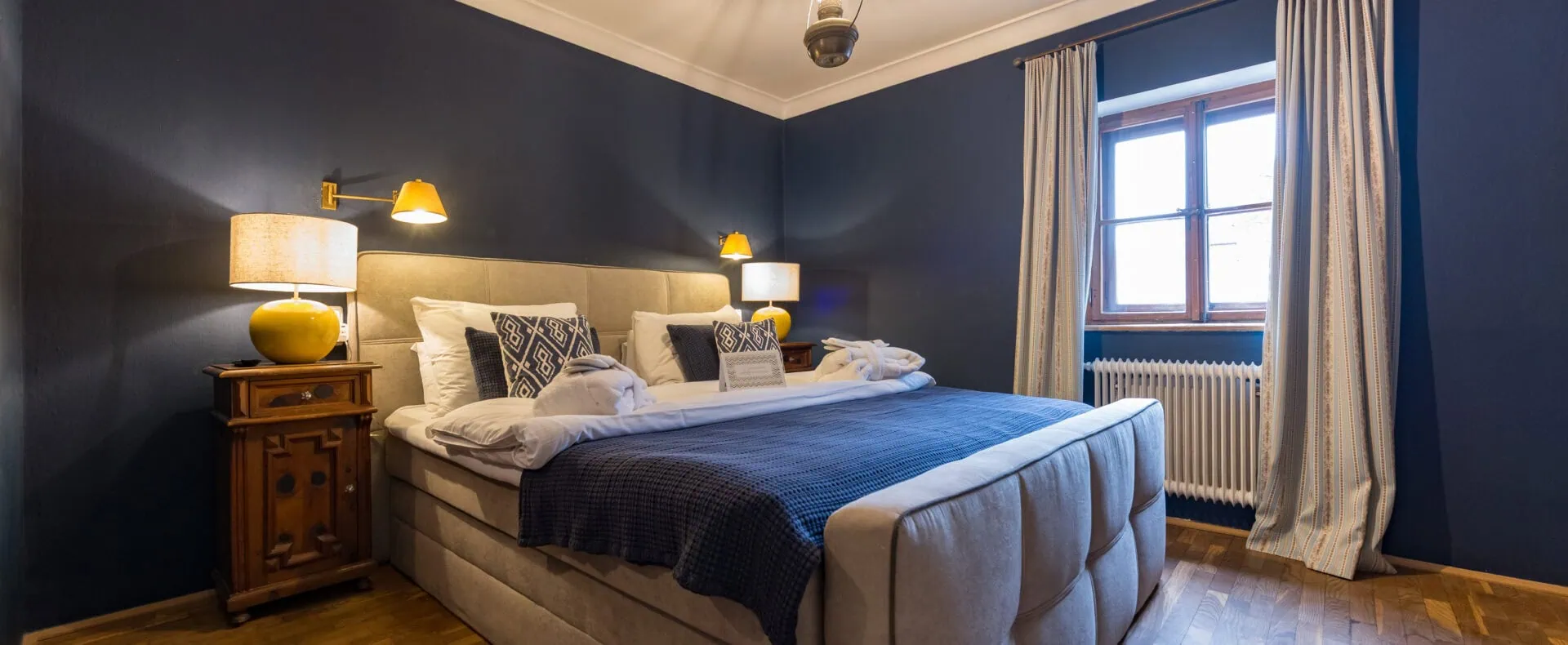 Gemütliches Doppelzimmer im Schlosswirt zu Anif mit blauem Interieur und großem Bett.