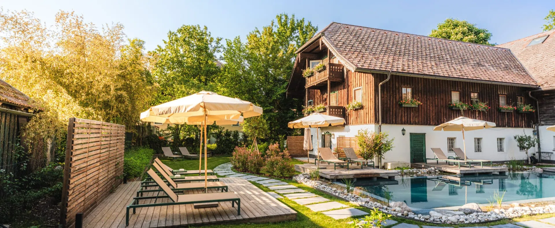 Garten mit Pool, Liegen und historischem Gebäude beim Schlosswirt zu Anif.