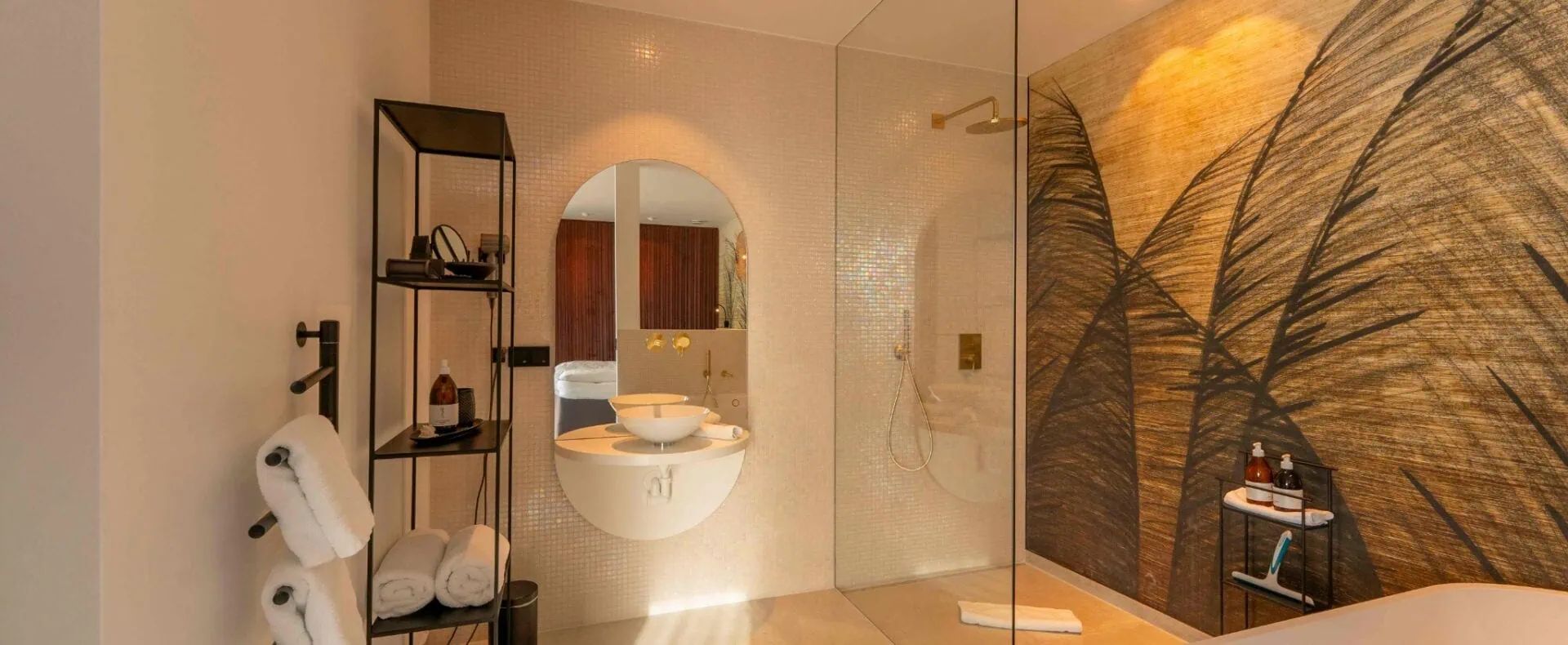 Modernes Badezimmer der ORANGE LOUNGE am Attersee mit Glasdusche, freistehender Badewanne und stilvoller Wandgestaltung.